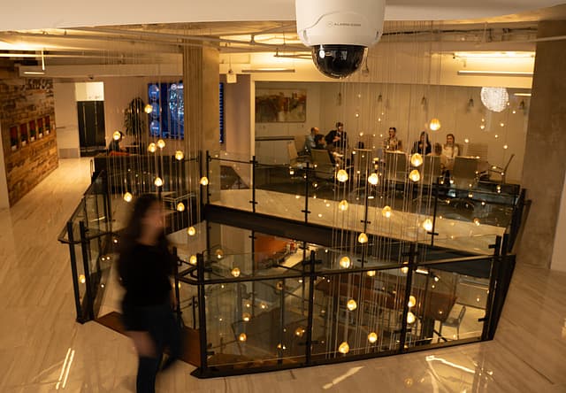 An Alarm.com dome camera overlooking a restaurant mezzanine during evening service
