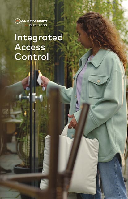 An employee badging into a glass storefront door with a keycard