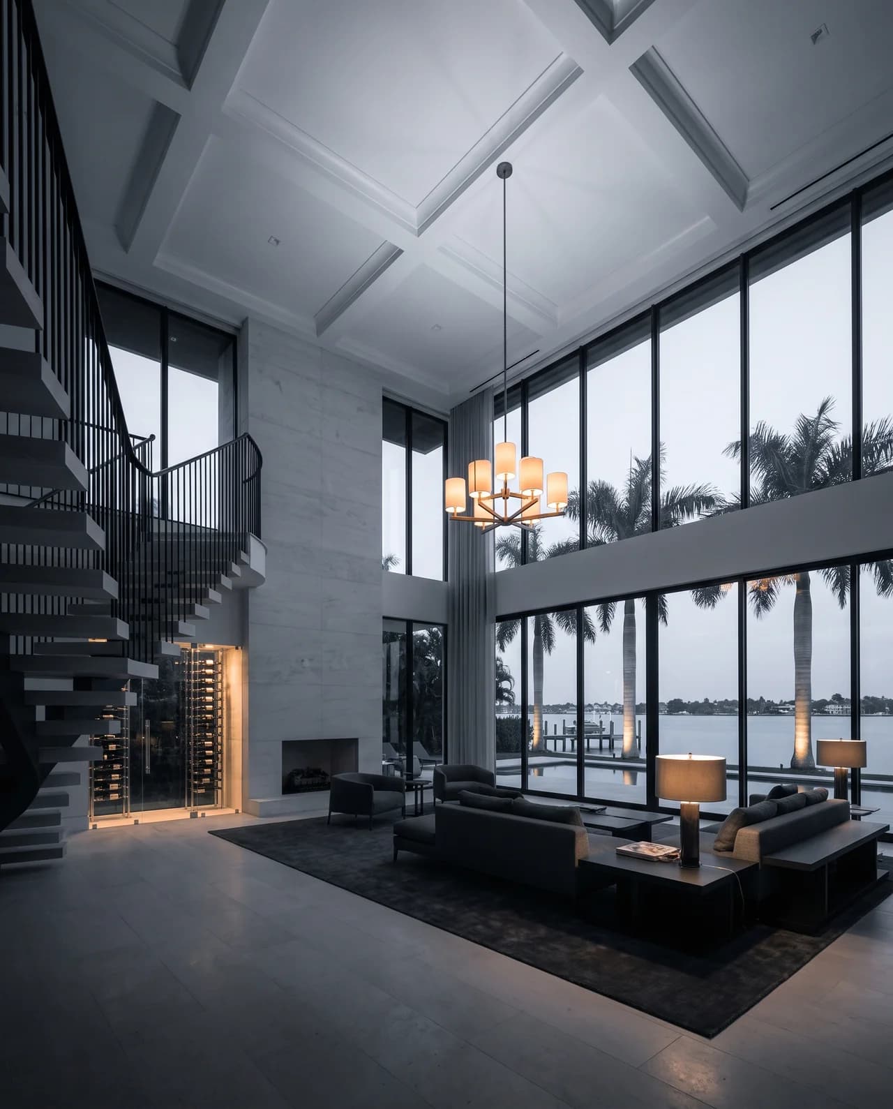 A sunlit great room in a waterfront estate, opening onto the pool and bay